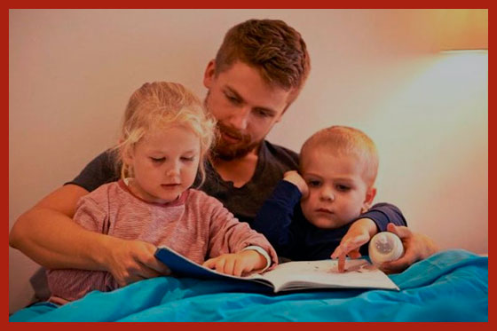 многодетный отец читает книжку детям